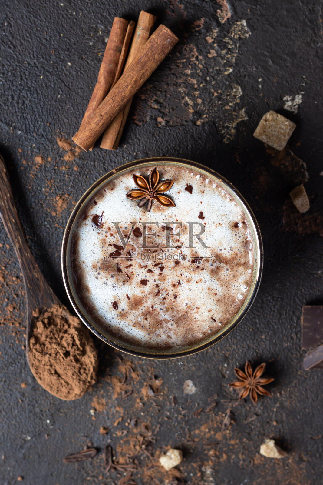 一杯热可可或热巧克力加八角和肉桂棒。秋季或冬季的传统饮料。黑暗的背景纹理。前视图。照片摄影图片