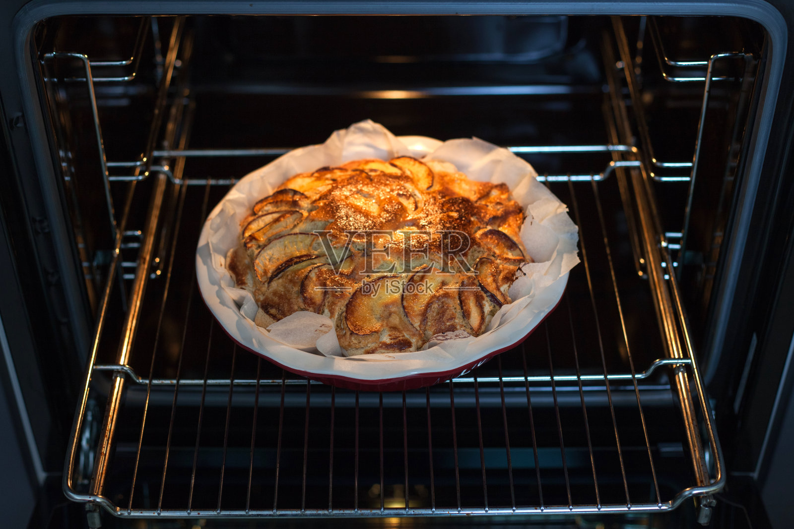 厨房里的烤箱里刚烤好的苹果派。苹果夏洛特自制烘焙。照片摄影图片