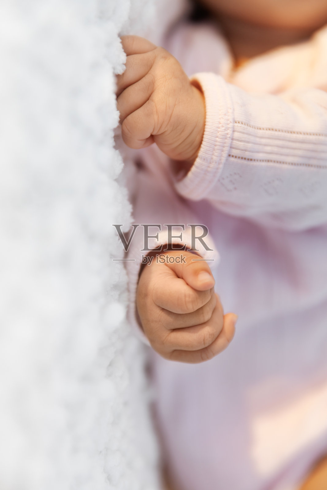 新生女婴紧握在白色毯子上，这是婴儿和产妇的概念照片摄影图片