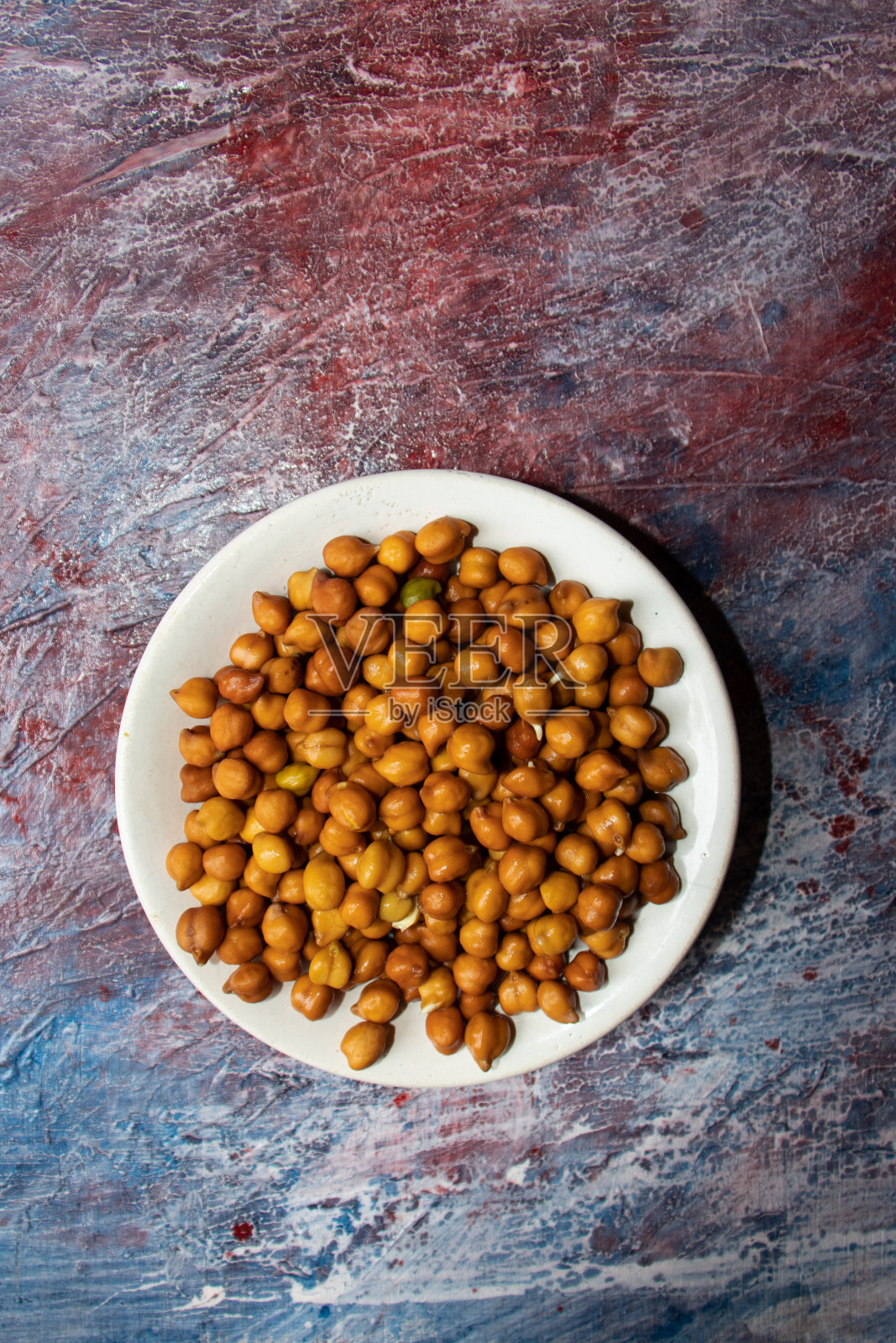 湿鹰嘴豆在盘子孤立的彩色纹理背景照片摄影图片