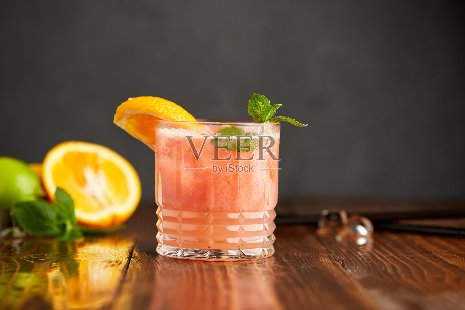 柚子和橙子混合冰沙在灰色的木质背景。提神的饮料照片摄影图片