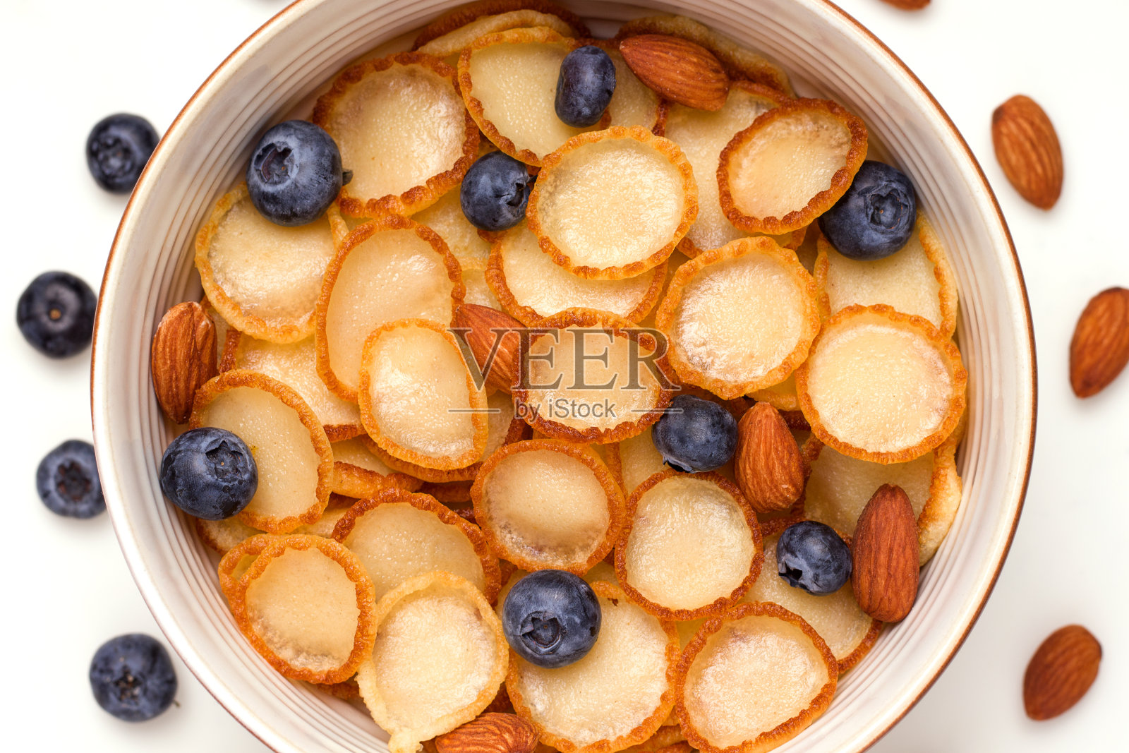 特写:一个小小的煎饼麦片早餐，碗里有蓝莓和杏仁照片摄影图片