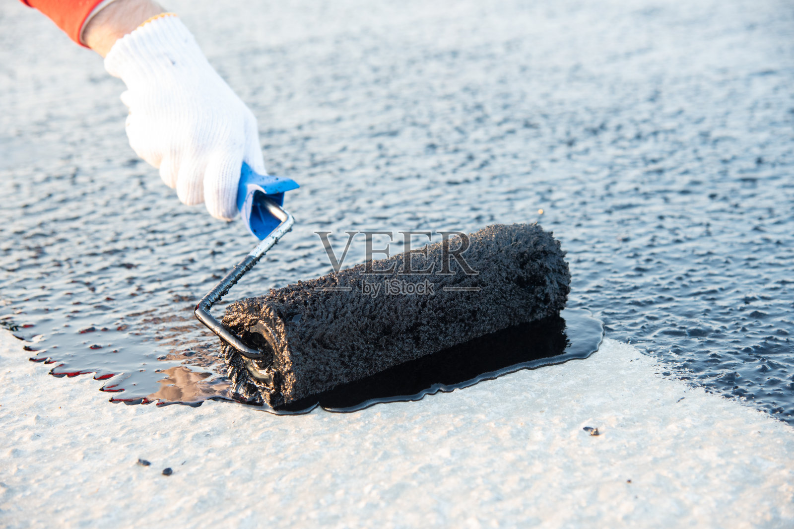 工人在地基上涂沥青乳胶油照片摄影图片