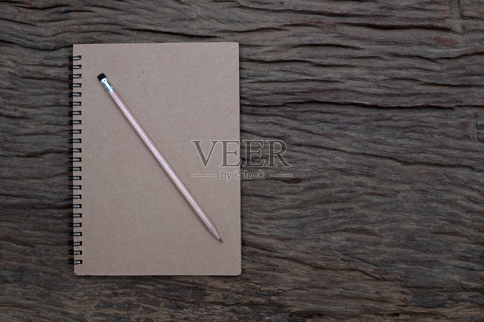 背景是旧木桌上的书本模型上面的铅笔，平躺照片，俯视图照片摄影图片