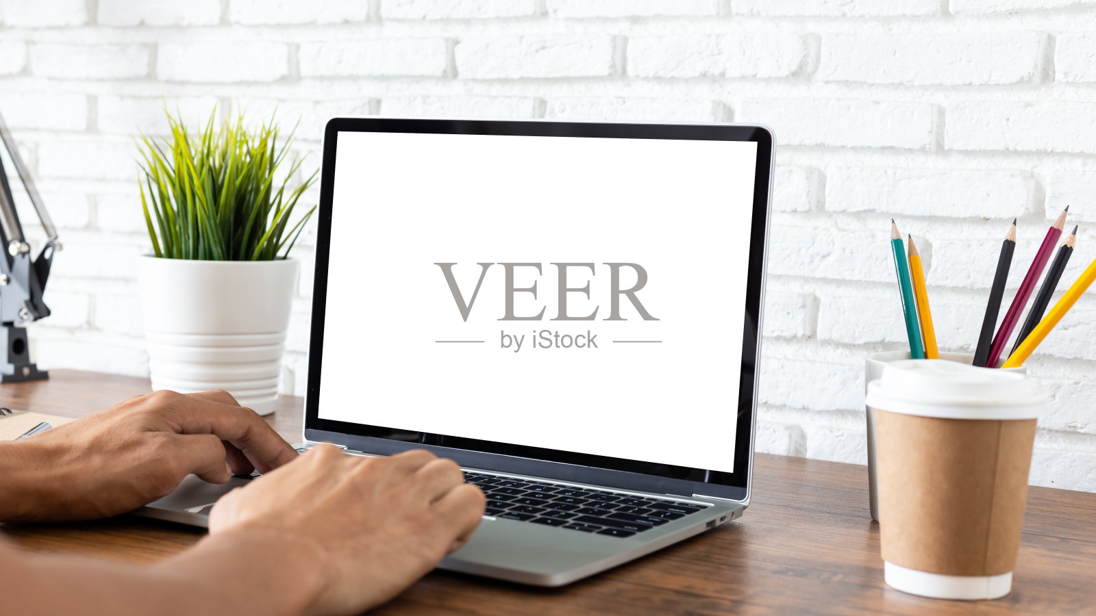 在家庭办公室木头桌子上工作的人空屏幕笔记本电脑。照片摄影图片