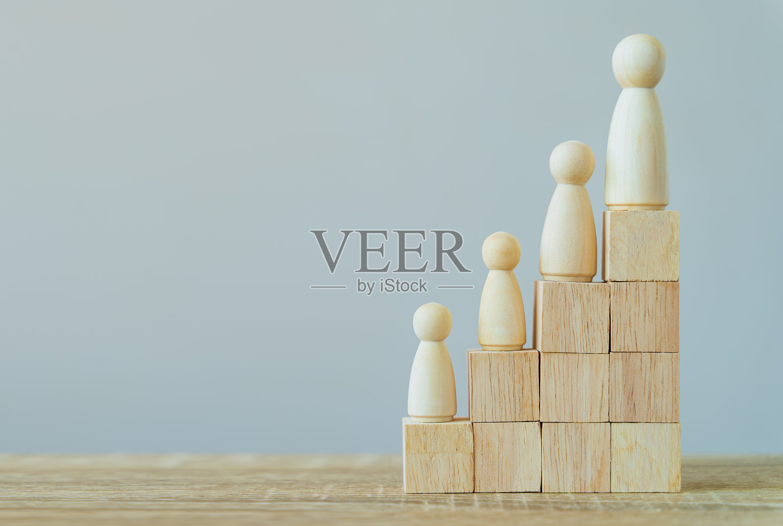 Banner Group of wood figure站在人力资源管理的层次上，在木堆上团队成功，领导力，业务进展，竞争上的灰色背景和复制空间。照片摄影图片