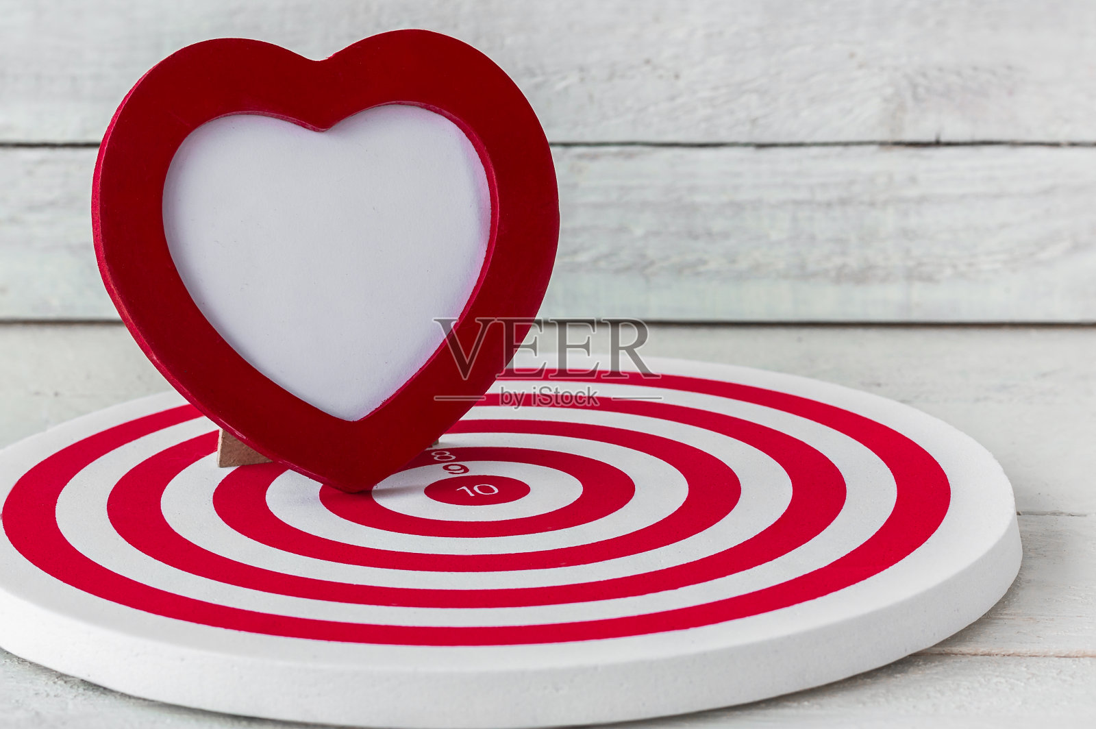 红心框架上的红色飞镖在白色的木头背景照片摄影图片