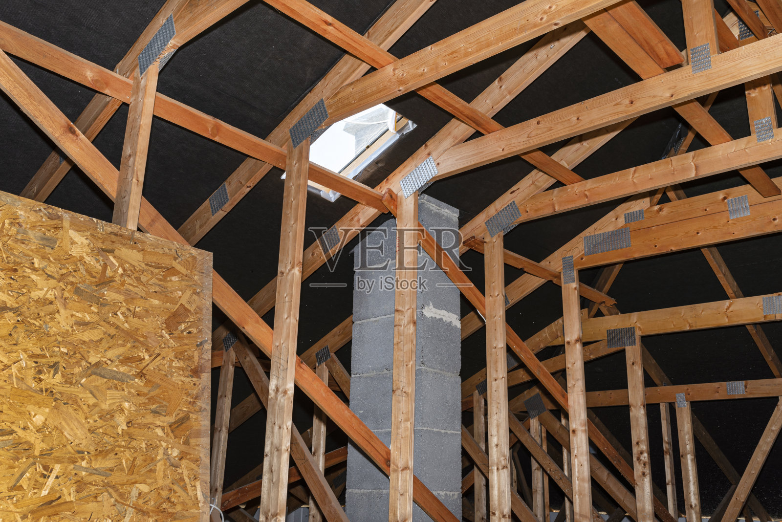 带有可见桁架的阁楼，用于扫烟囱的屋顶开口和带有系统烟囱。照片摄影图片