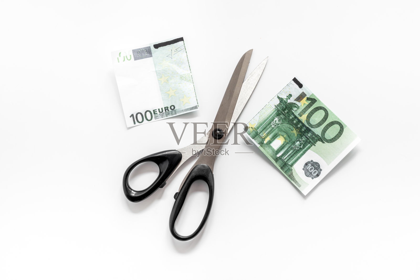 欧元汇率下跌。剪刀剪美元钞票照片摄影图片