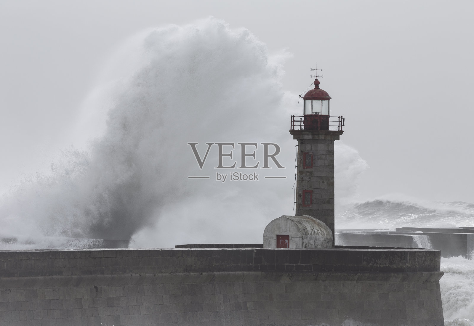 10米高的巨浪掠过葡萄牙波尔图的“Felgueiras”灯塔。照片摄影图片