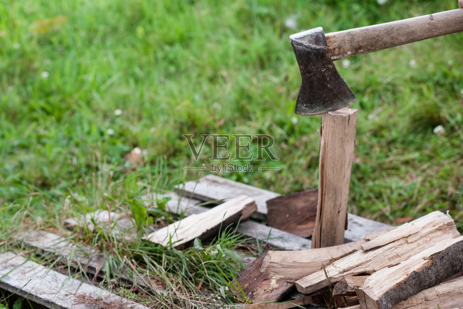 一把铁斧头竖在田野上。有人砍木头照片摄影图片