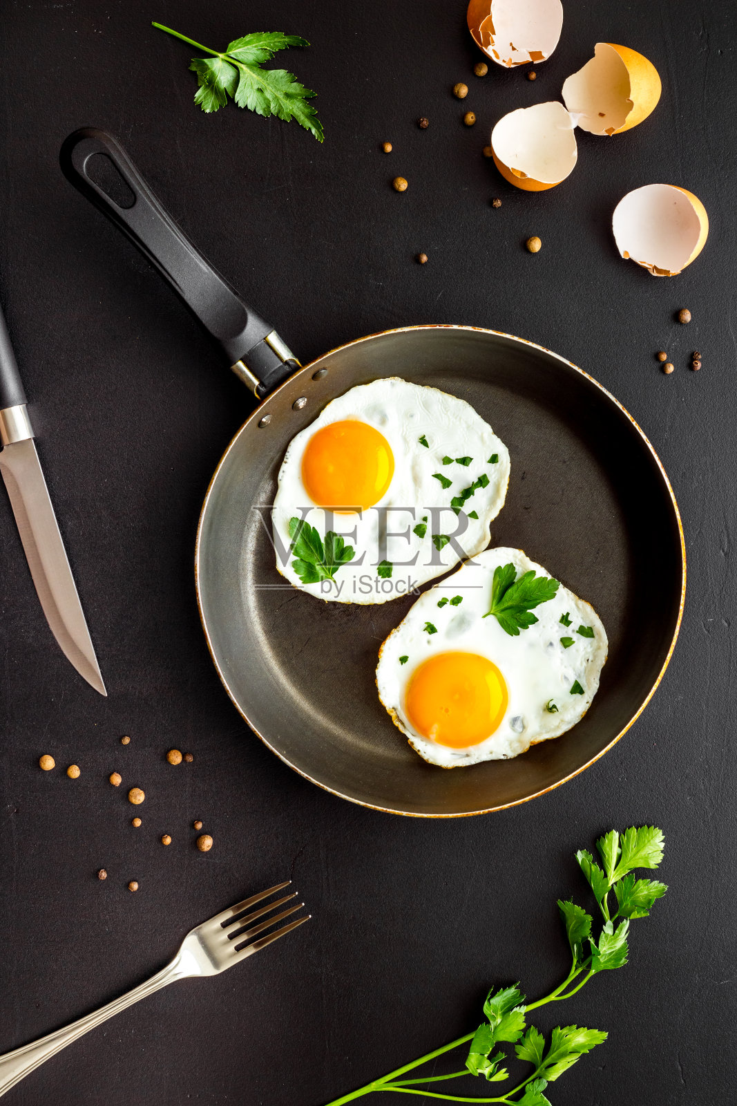 煎蛋在煎锅上，黑色的书桌自上而下照片摄影图片