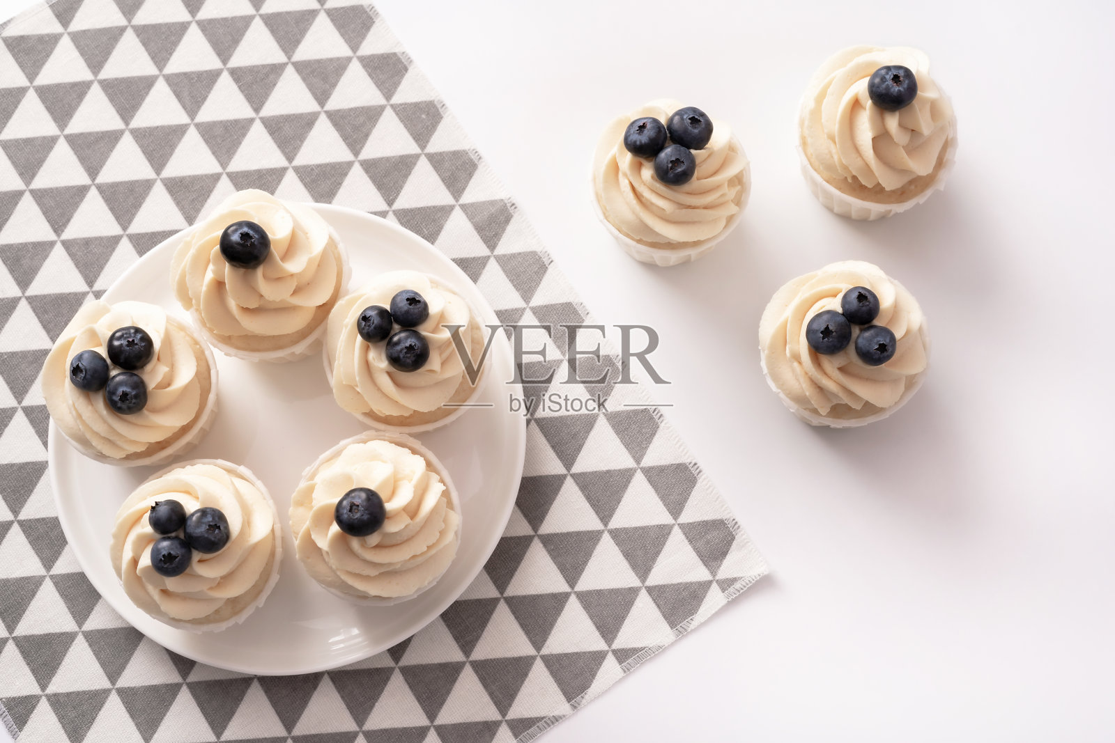 瓷盘上有蓝莓和香草奶油的自制小蛋糕。平的风格。照片摄影图片
