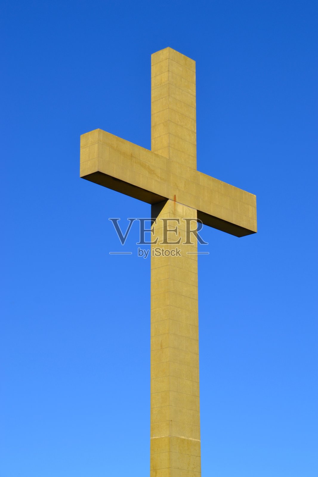 在钴蓝色晴朗的天空下孤立地敲击着巨大的混凝土十字架或十字架照片摄影图片