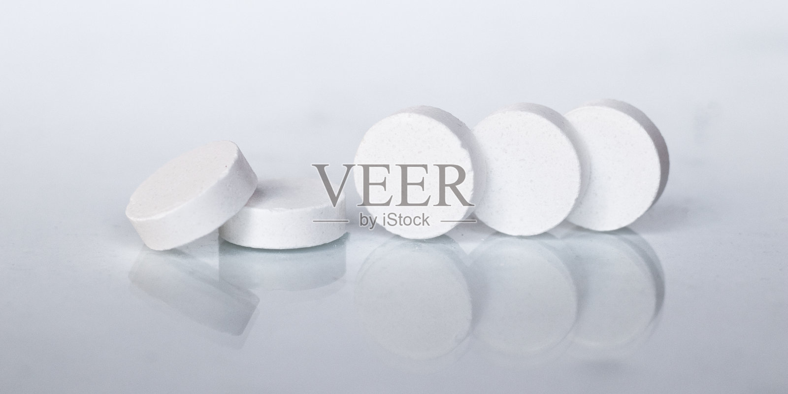五粒白色药丸，白色背景特写。微距图片的主题是药物和医药照片摄影图片