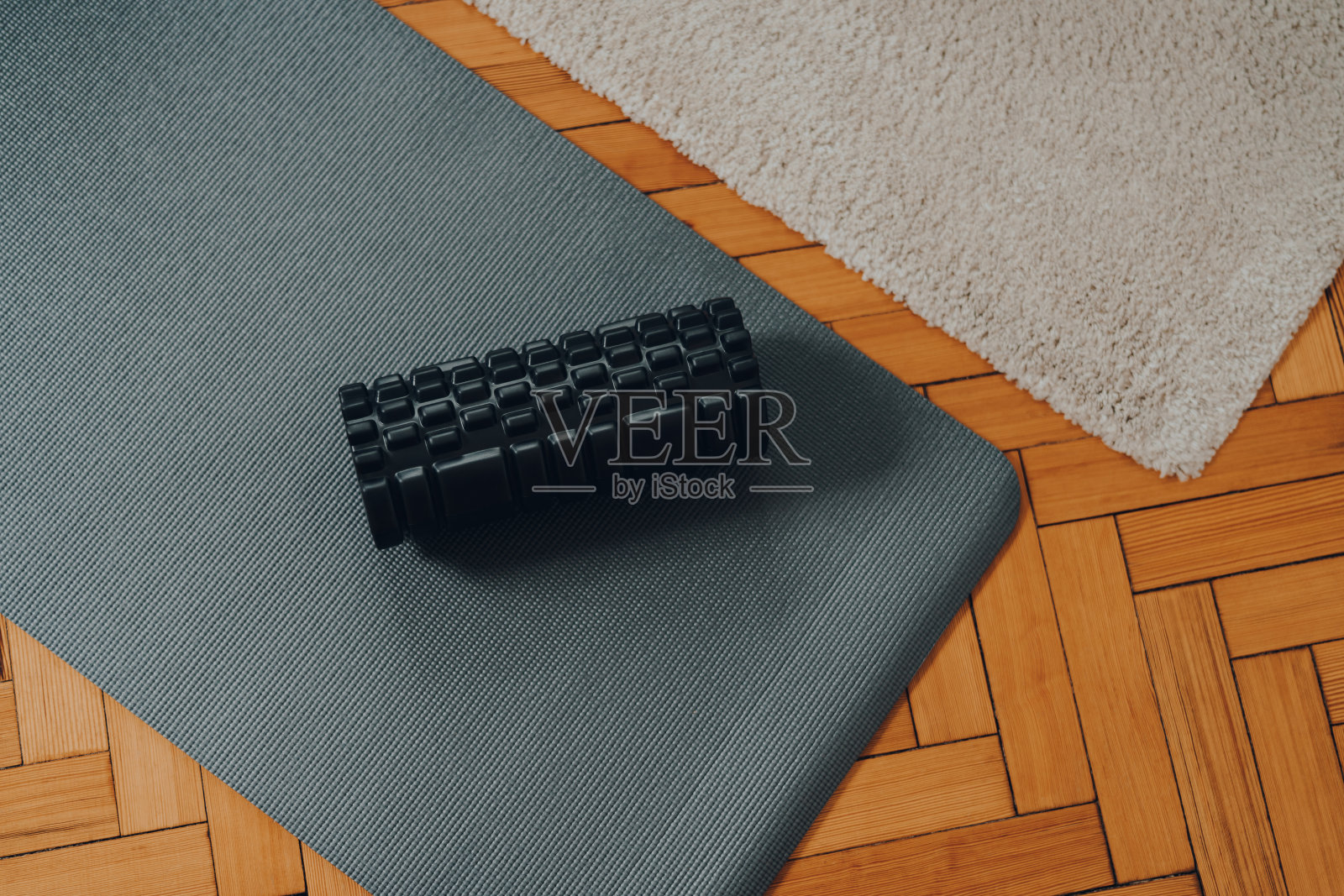 泡沫辊和健身垫在旧拼花地板上，选择性的焦点。照片摄影图片