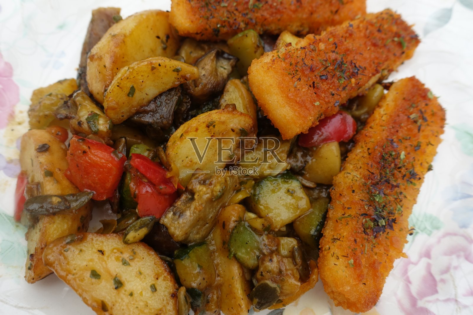 裹有面包屑的鳕鱼条，配上混合的蔬菜炖菜照片摄影图片