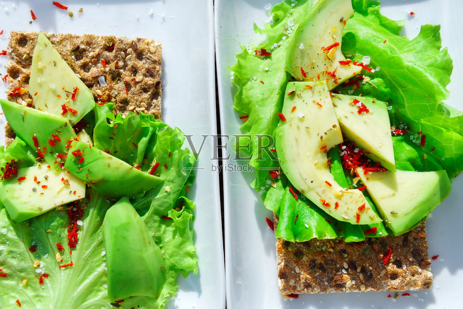 美味的早餐，酥脆面包片上的鳄梨。自制美味早餐的特写。饮食是健康的。照片摄影图片