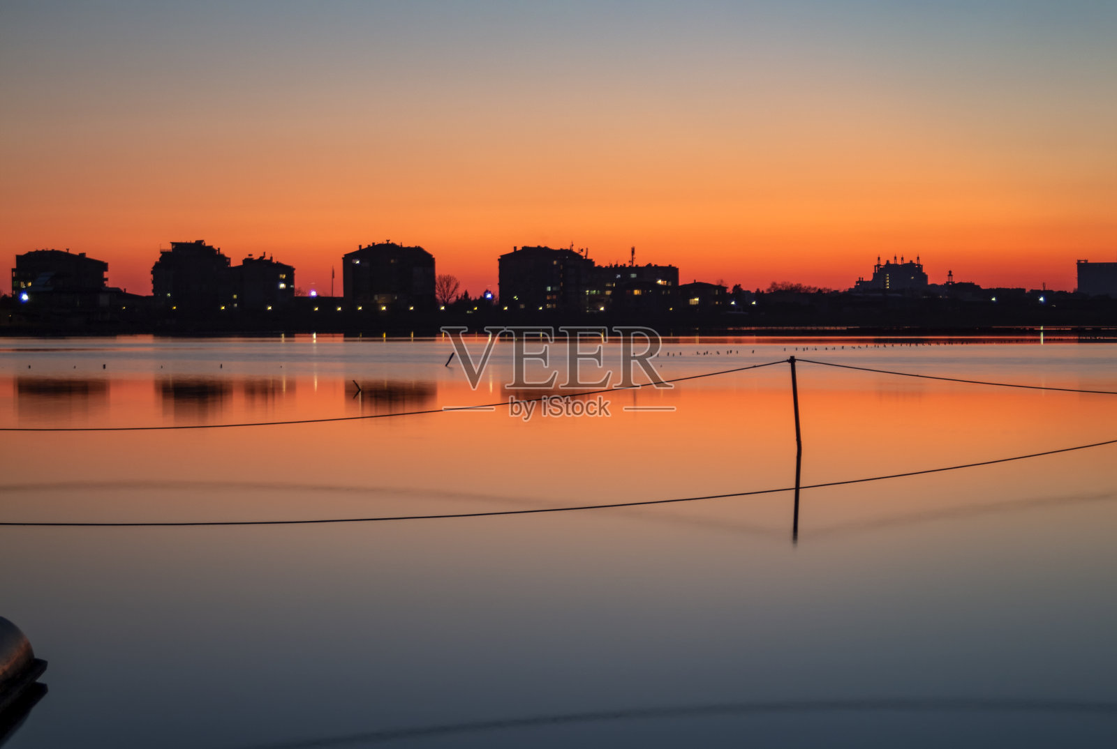 日落后的魔力之光。在地平线上有反射的建筑。照片摄影图片