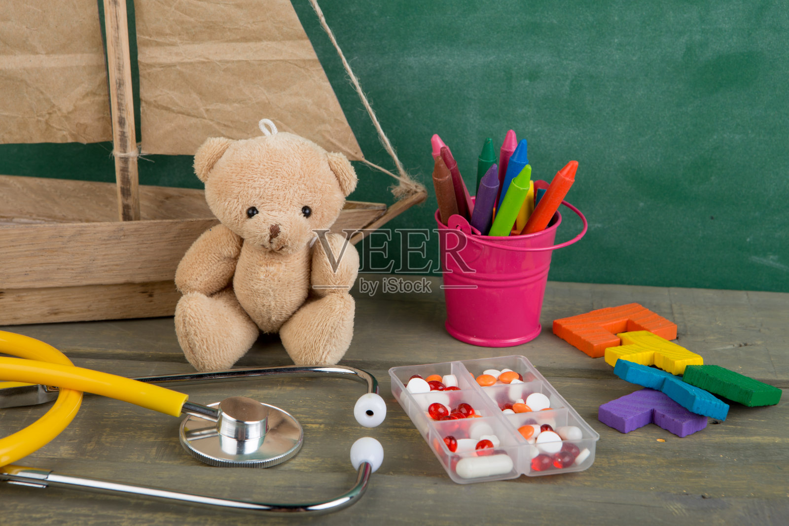 足科医生工作场所-玩具熊，听诊器和木桌上的药品-儿童保健理念照片摄影图片