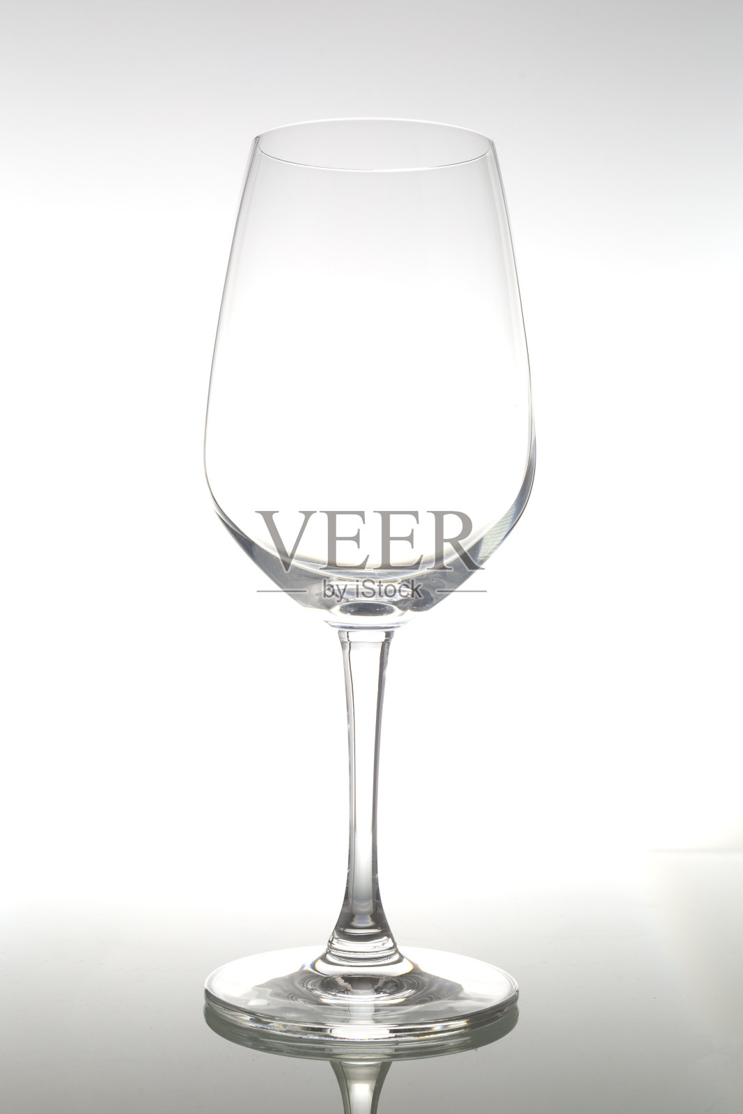 空酒杯放在玻璃桌上。白色背景上的空杯子。照片摄影图片