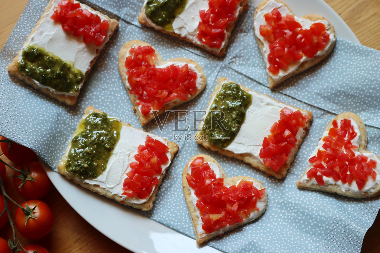 木桌上的盘子里放着红心和意大利国旗形状的沙拉饼干照片摄影图片