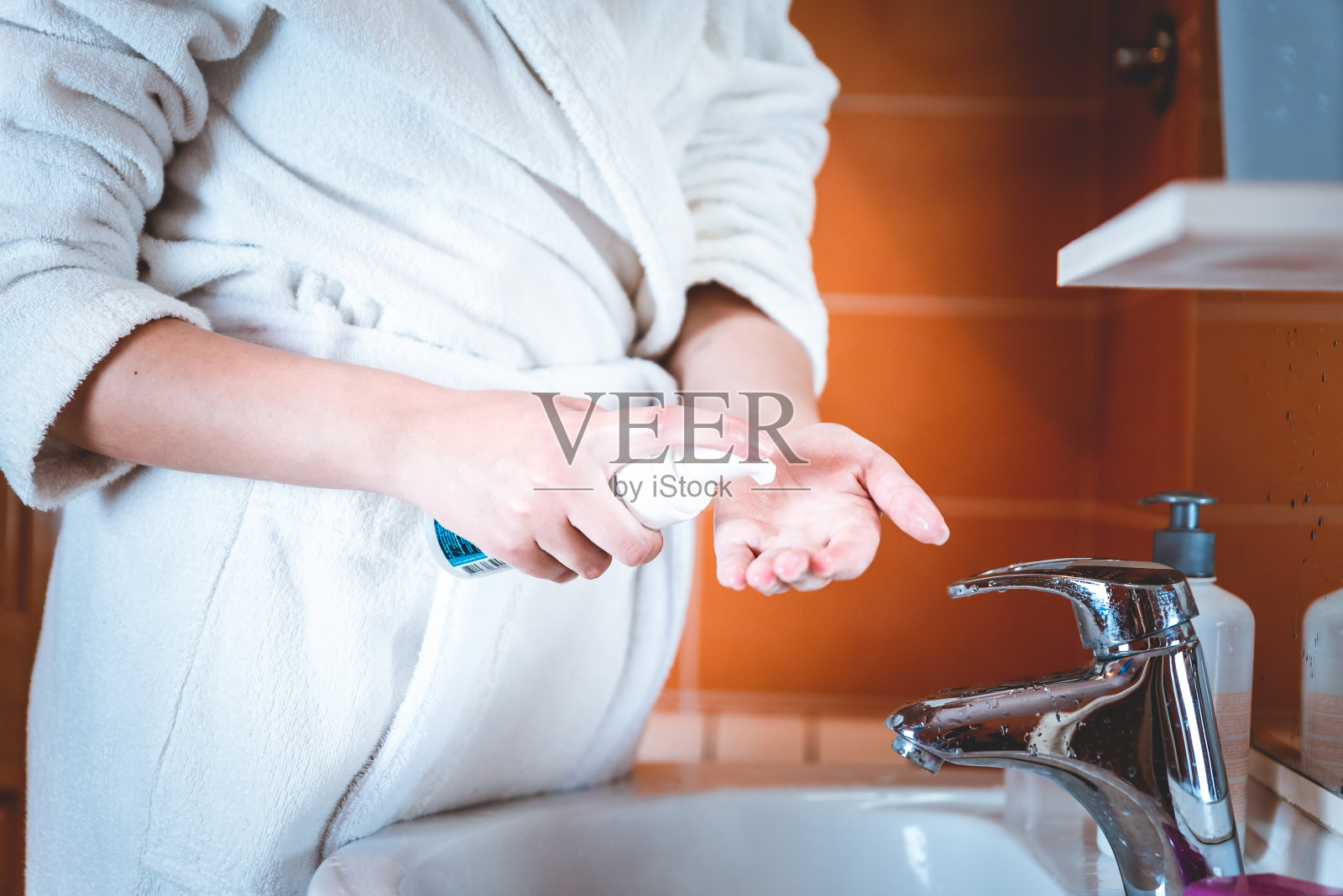 一个女孩在浴室里倒洗面奶照片摄影图片