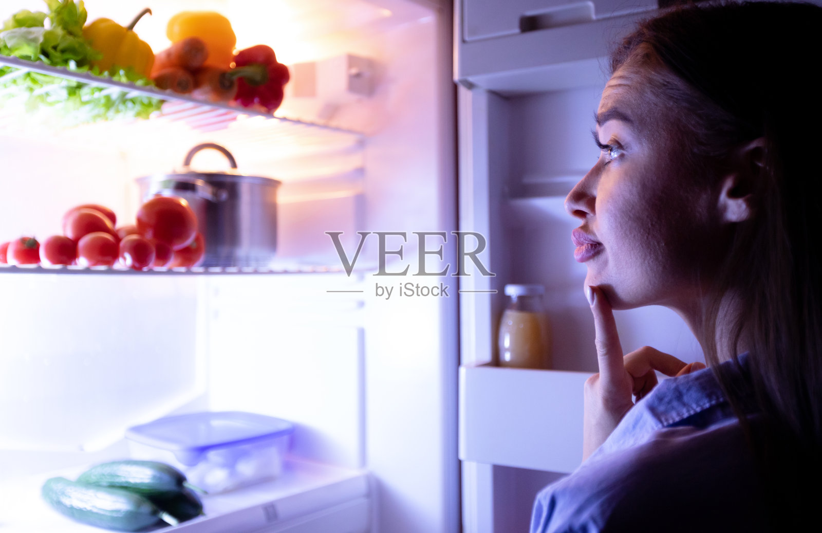 体贴的主妇选择晚上在冰箱里吃什么照片摄影图片