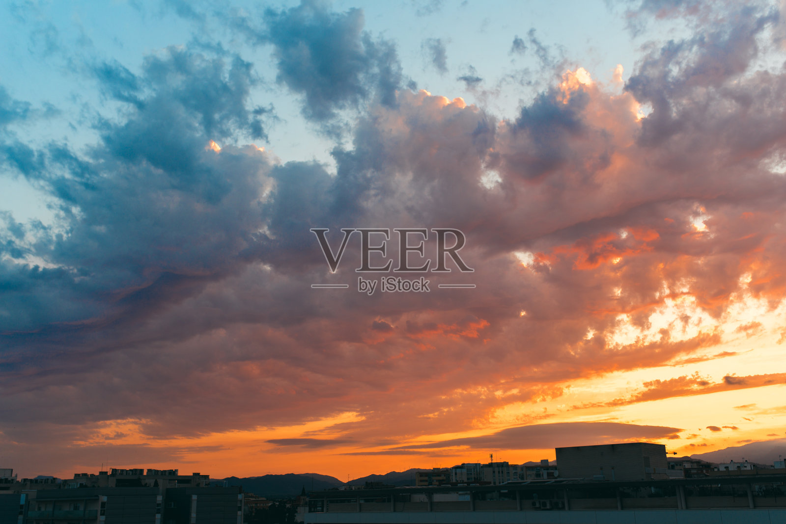 美丽的日落天空之上的云与戏剧性的光。蓝色和橙色。照片摄影图片