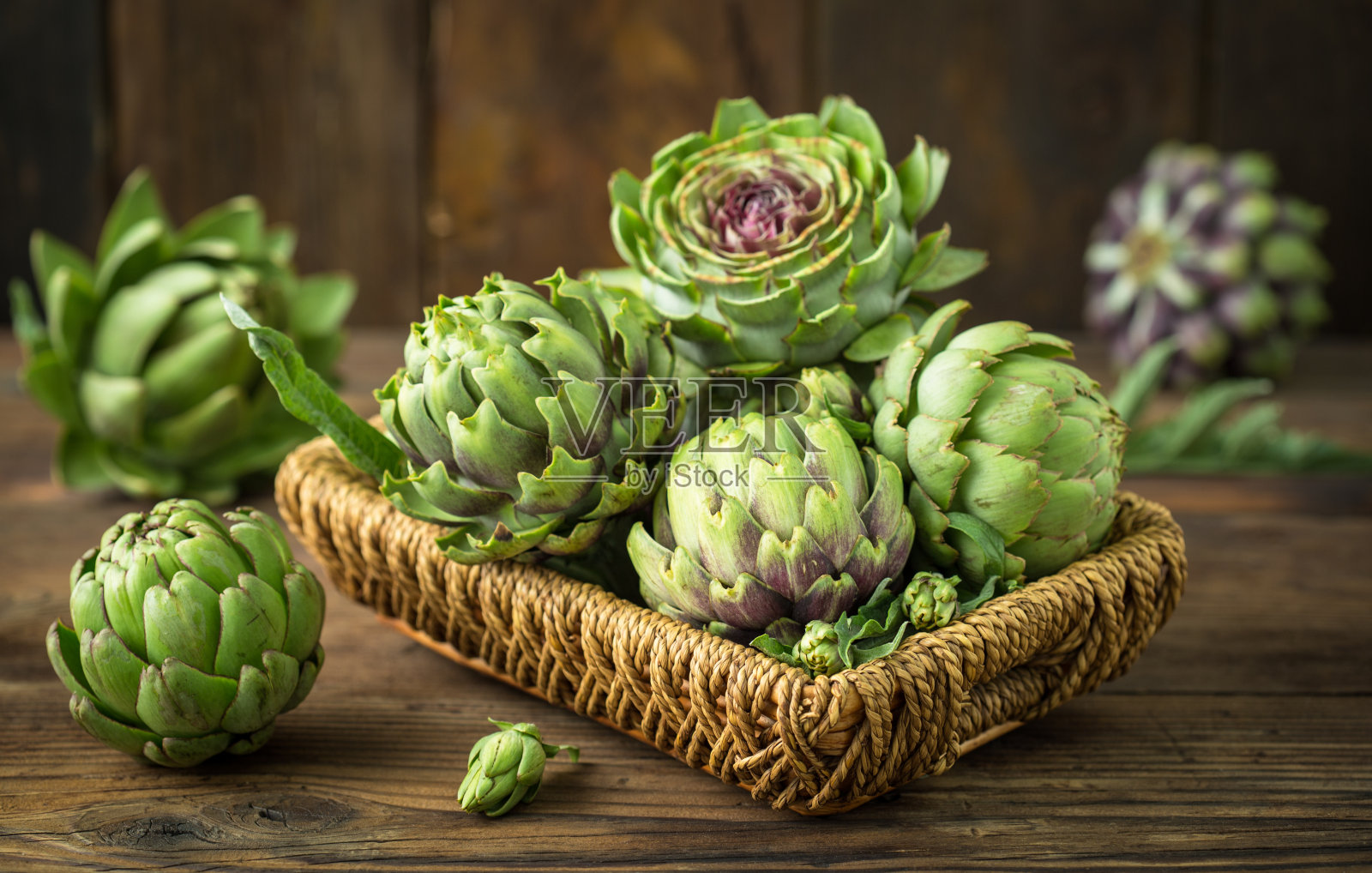 木桌上放着新鲜生的洋蓟照片摄影图片