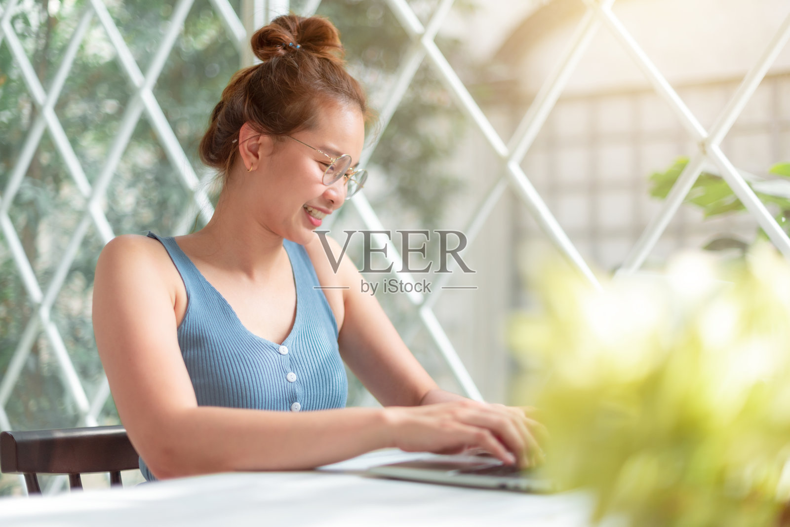 漂亮的女孩在家庭办公室用笔记本电脑工作。照片摄影图片