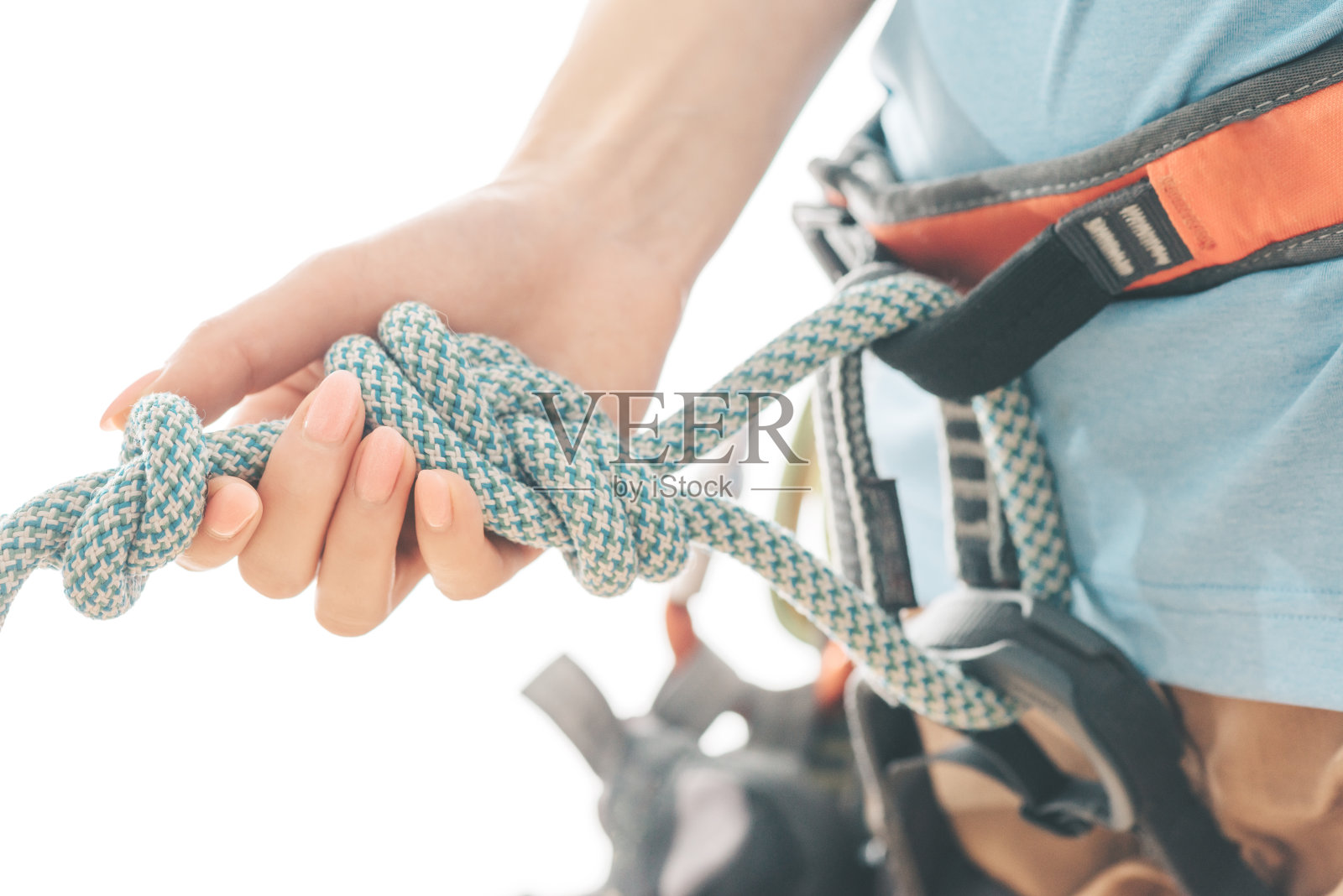 抱着安全绳的登山者，特写。照片摄影图片