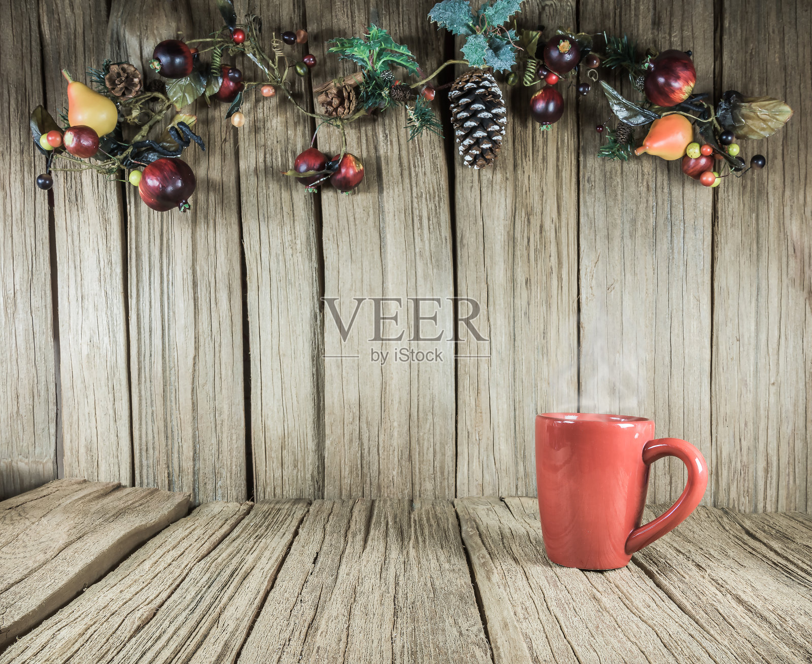 一杯红色的咖啡，在旧的镶板背景上点缀着圣诞装饰。照片摄影图片