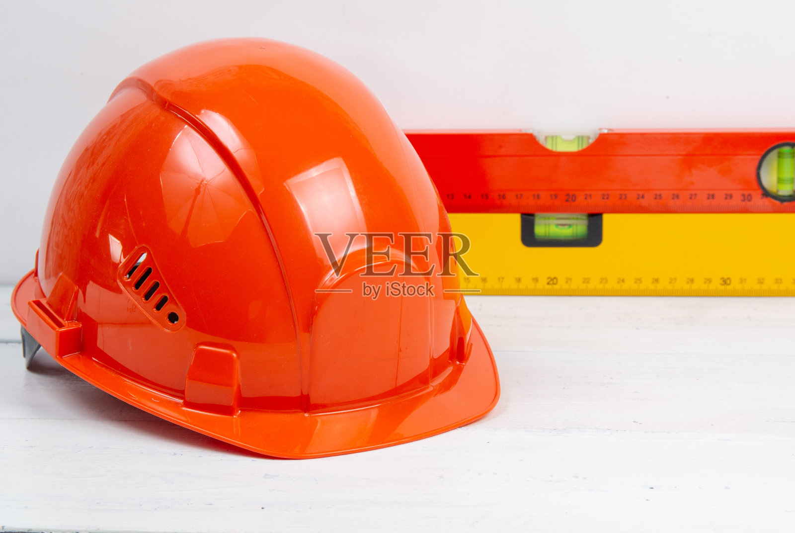 安全帽和建筑水平放在一张白色的桌子上。照片摄影图片