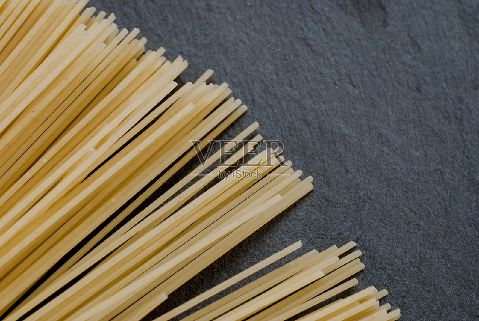 一张长长的意大利面放在一张昏暗的桌子上照片摄影图片