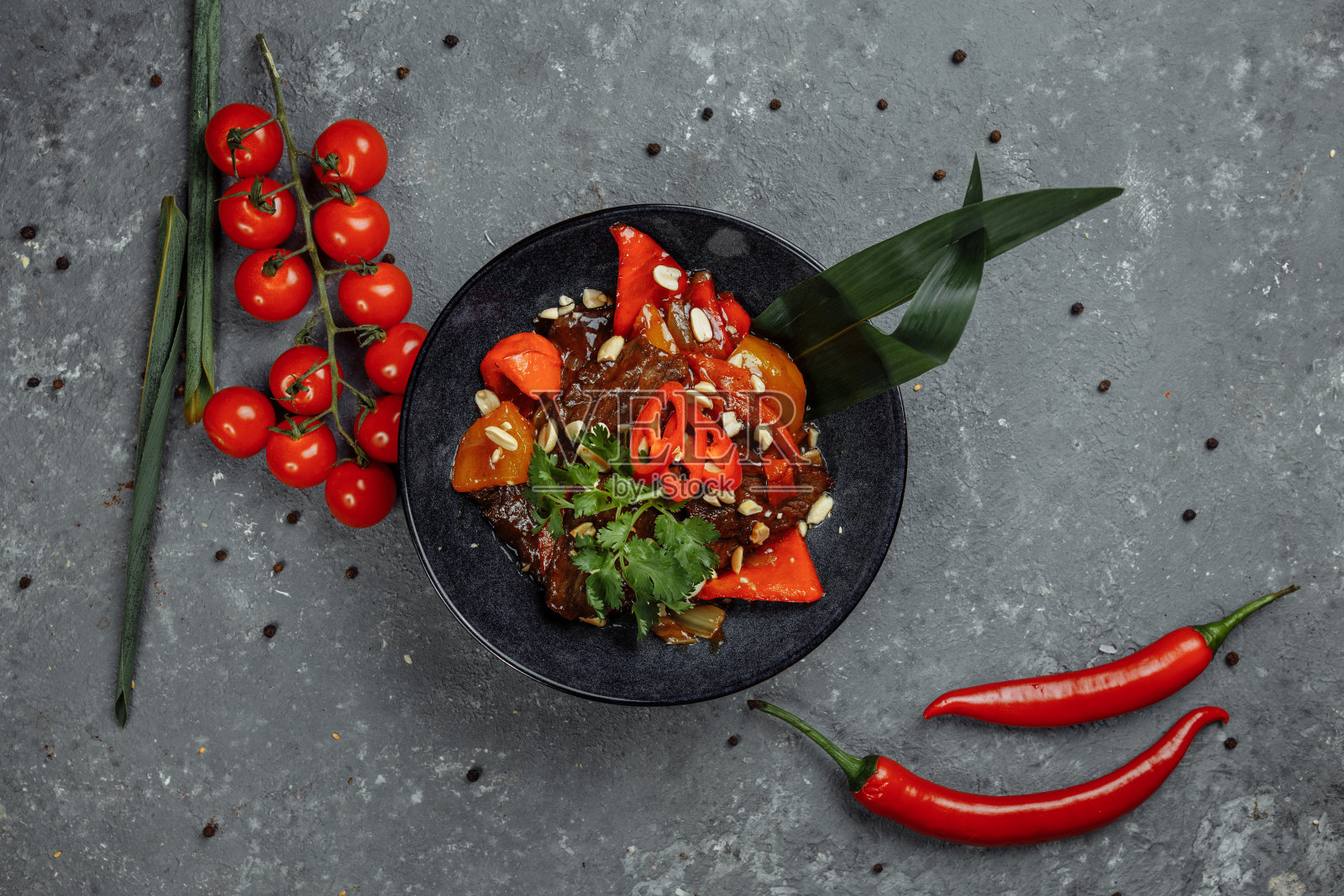 牛肉锅。传统的蒙古牛肉用中国铸铁炒锅用筷子炒，石板背景。俯视图，复制空间照片摄影图片