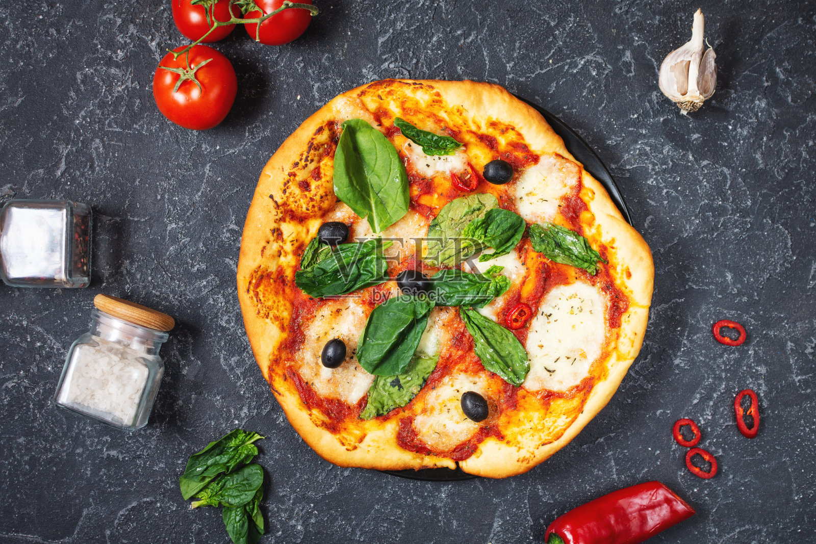 自制玛格丽塔披萨配马苏里拉奶酪，西红柿和罗勒在黑色的石头背景照片摄影图片