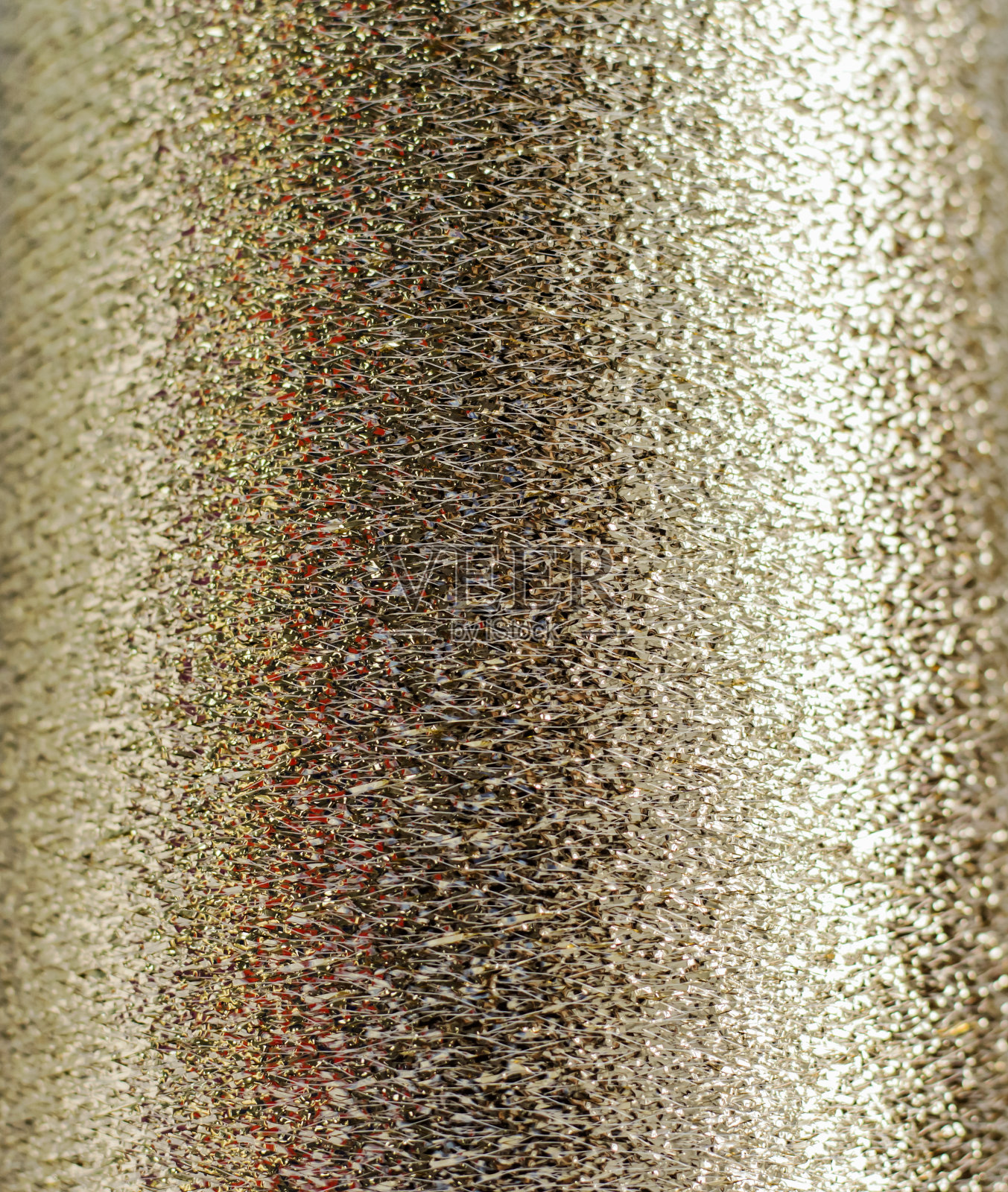 缠绕在线轴上的金色金属线作为金色的背景照片摄影图片