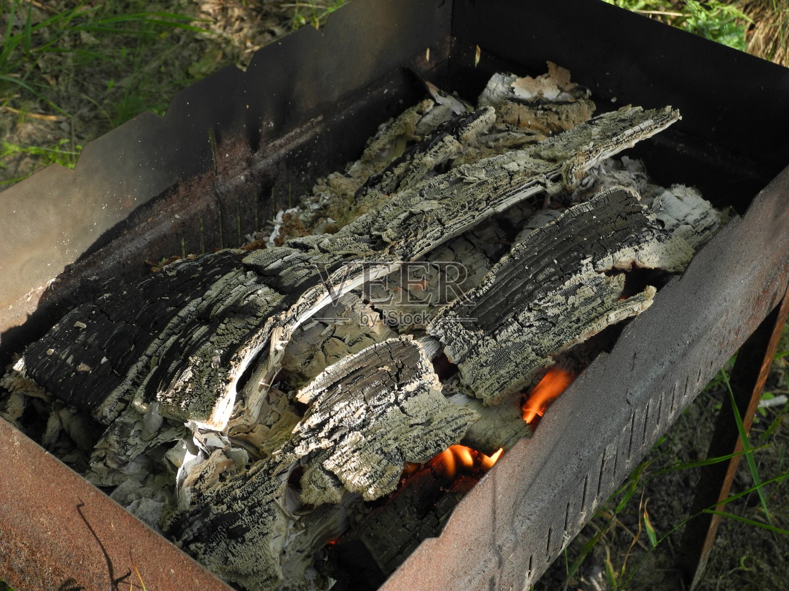 在金属烤架上烧过的木柴照片摄影图片