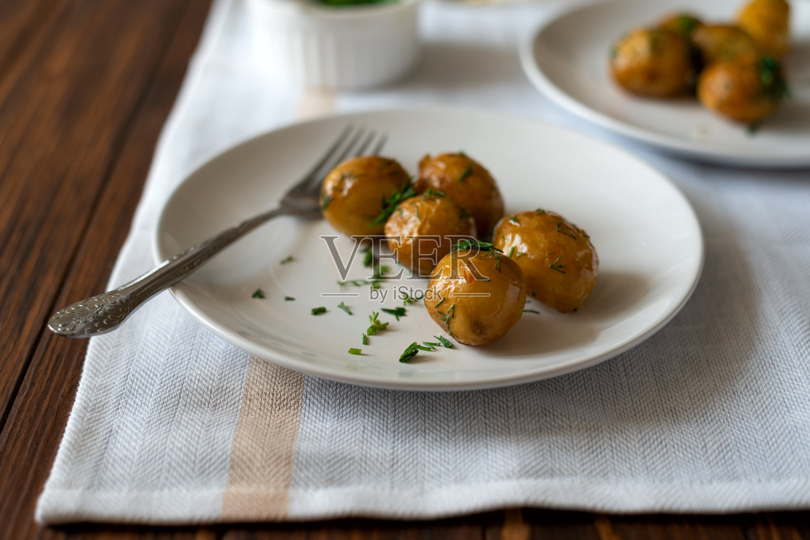 烤土豆，配上大蒜和香草。夏天食物吃。照片摄影图片