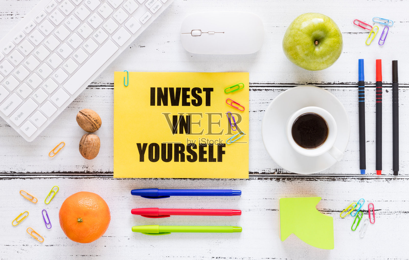 一个写着“为自己投资”的工作场所。个人或商业发展和自我实现的概念。键盘笔健康零食照片摄影图片