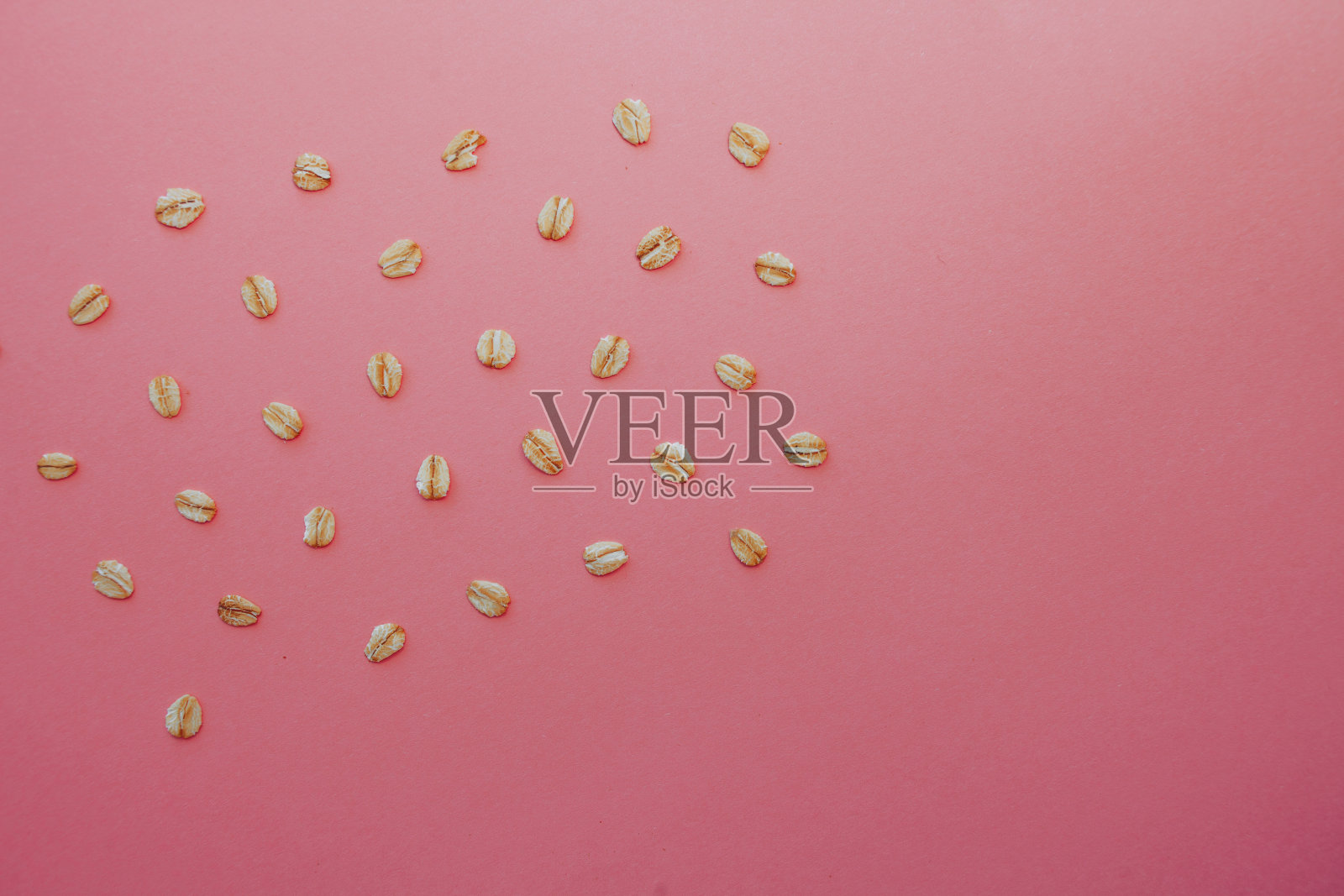 粉红色背景上的燕麦颗粒图案。照片摄影图片