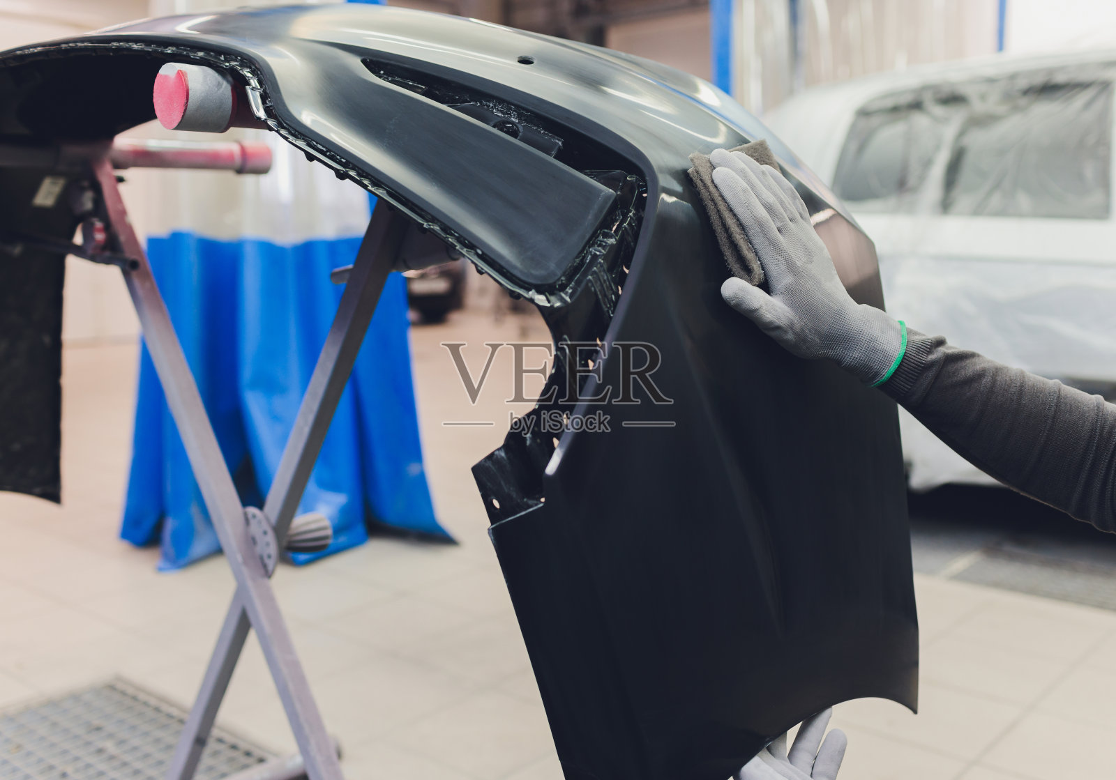 汽车修理工用动力缓冲机涂上光剂，为汽车喷漆工作做准备照片摄影图片