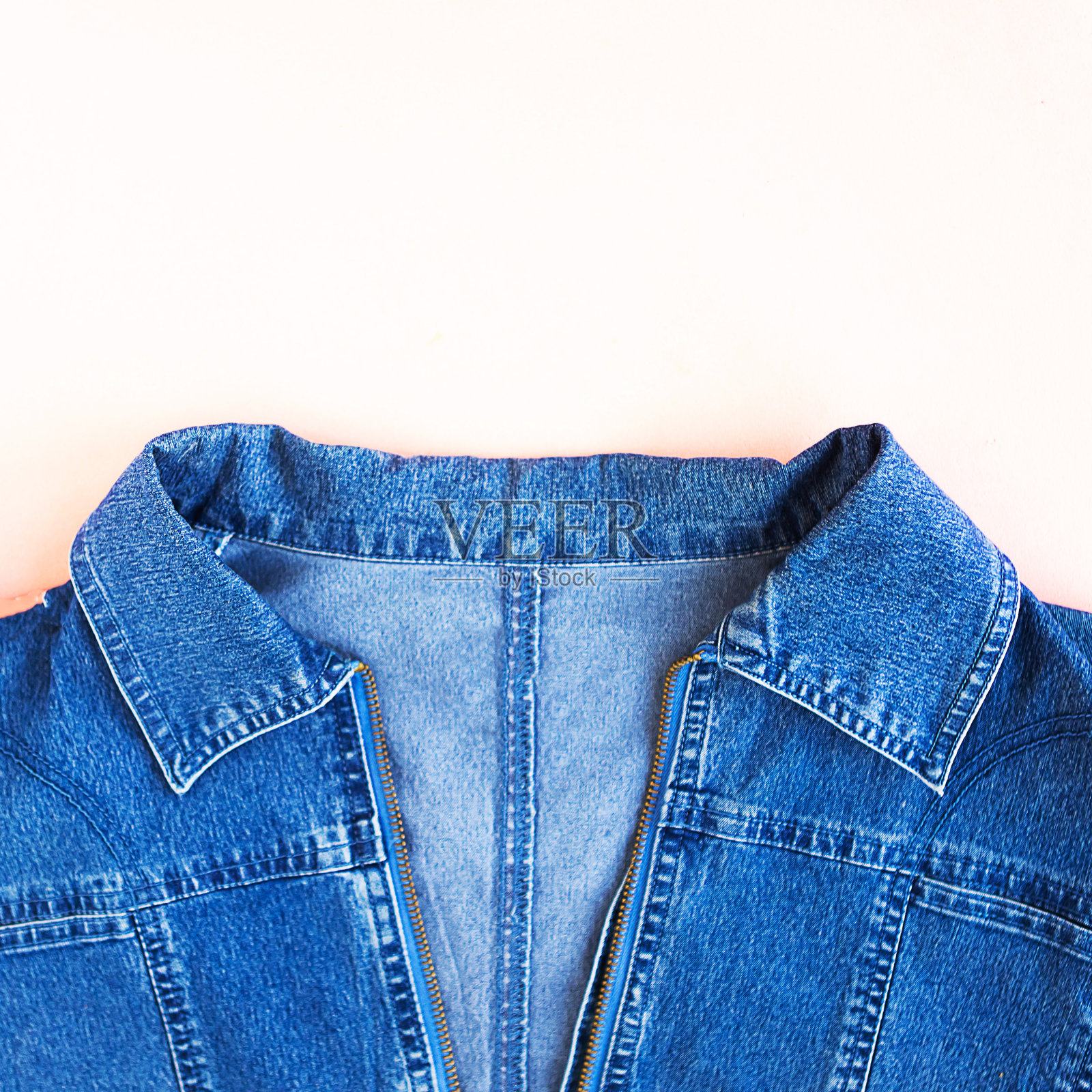 蓝色牛仔女人夹克上粉粉背景拷贝空间俯视图平lay。时尚背景。牛仔质地照片摄影图片