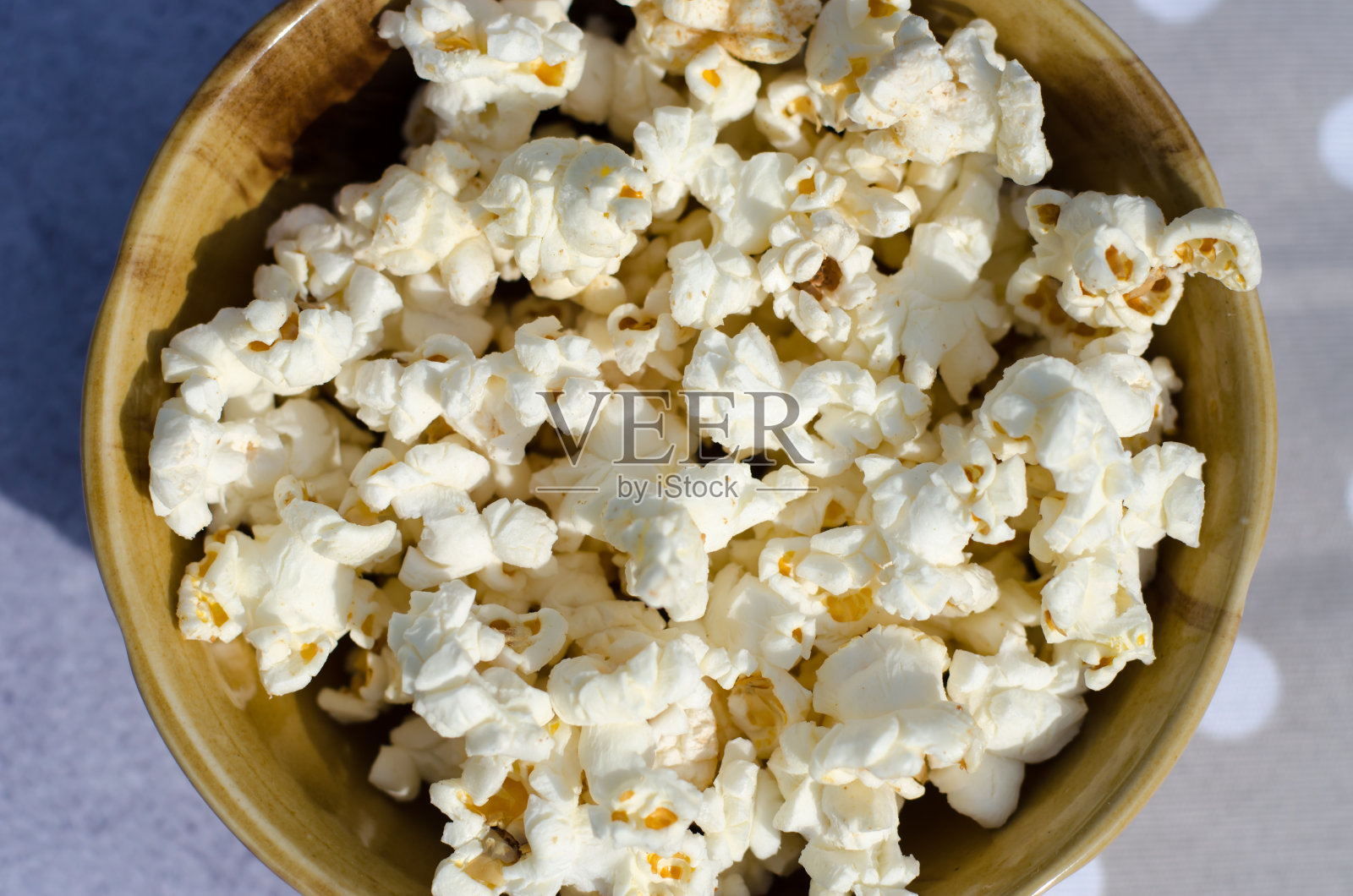 爆米花在一个棕色碗特写俯视图。照片摄影图片