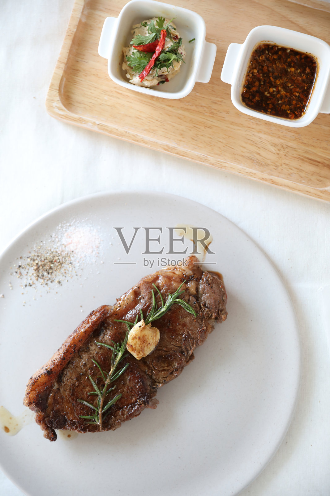 白桌子上的牛排和沙拉照片摄影图片