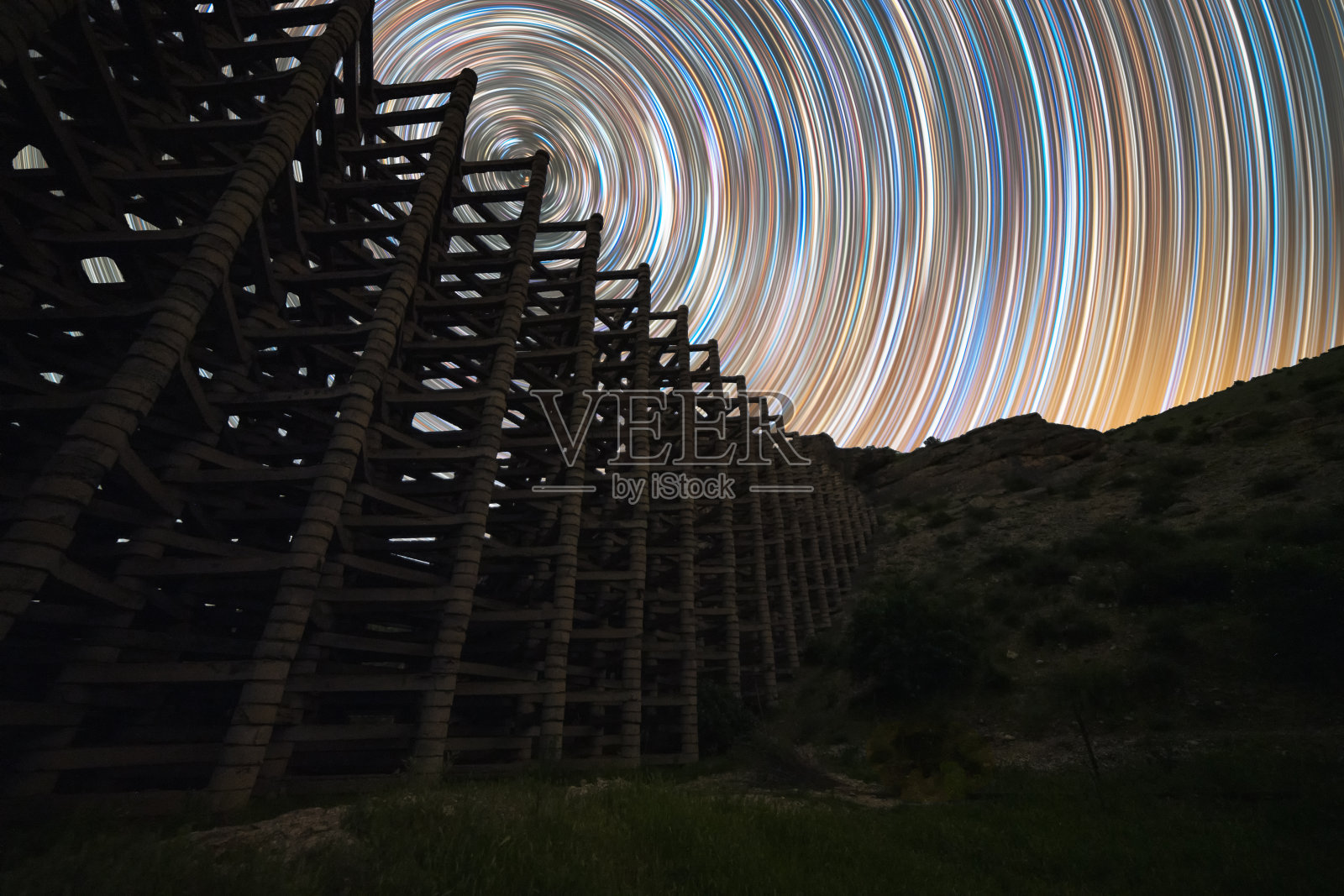 美丽的夜景与明亮的银河时光流逝和古老的石头建筑。夜星迹。照片摄影图片