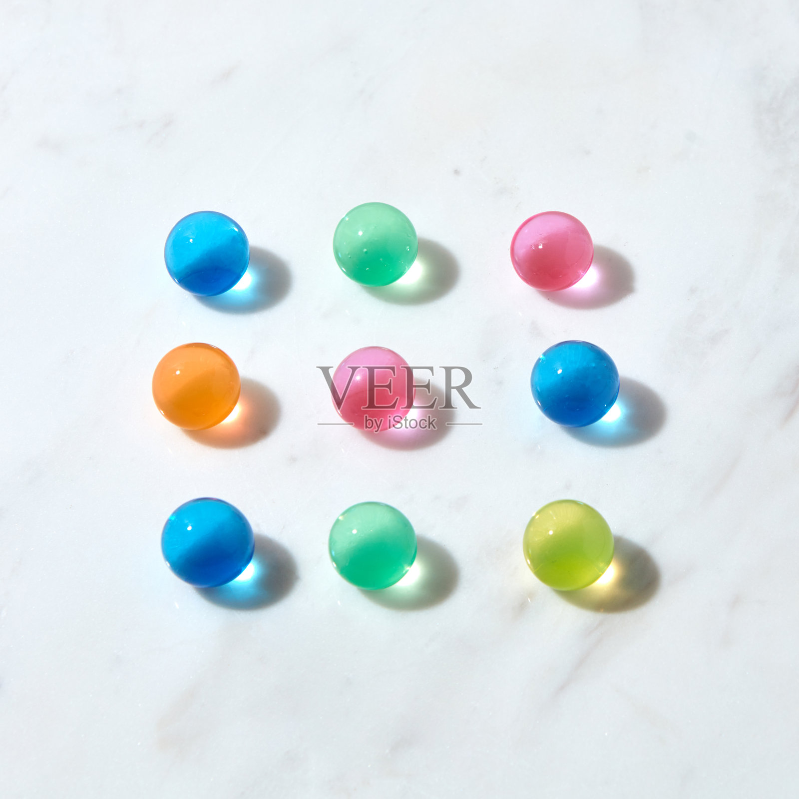 从水凝胶彩色球在灰色大理石桌子上的方形图案。照片摄影图片