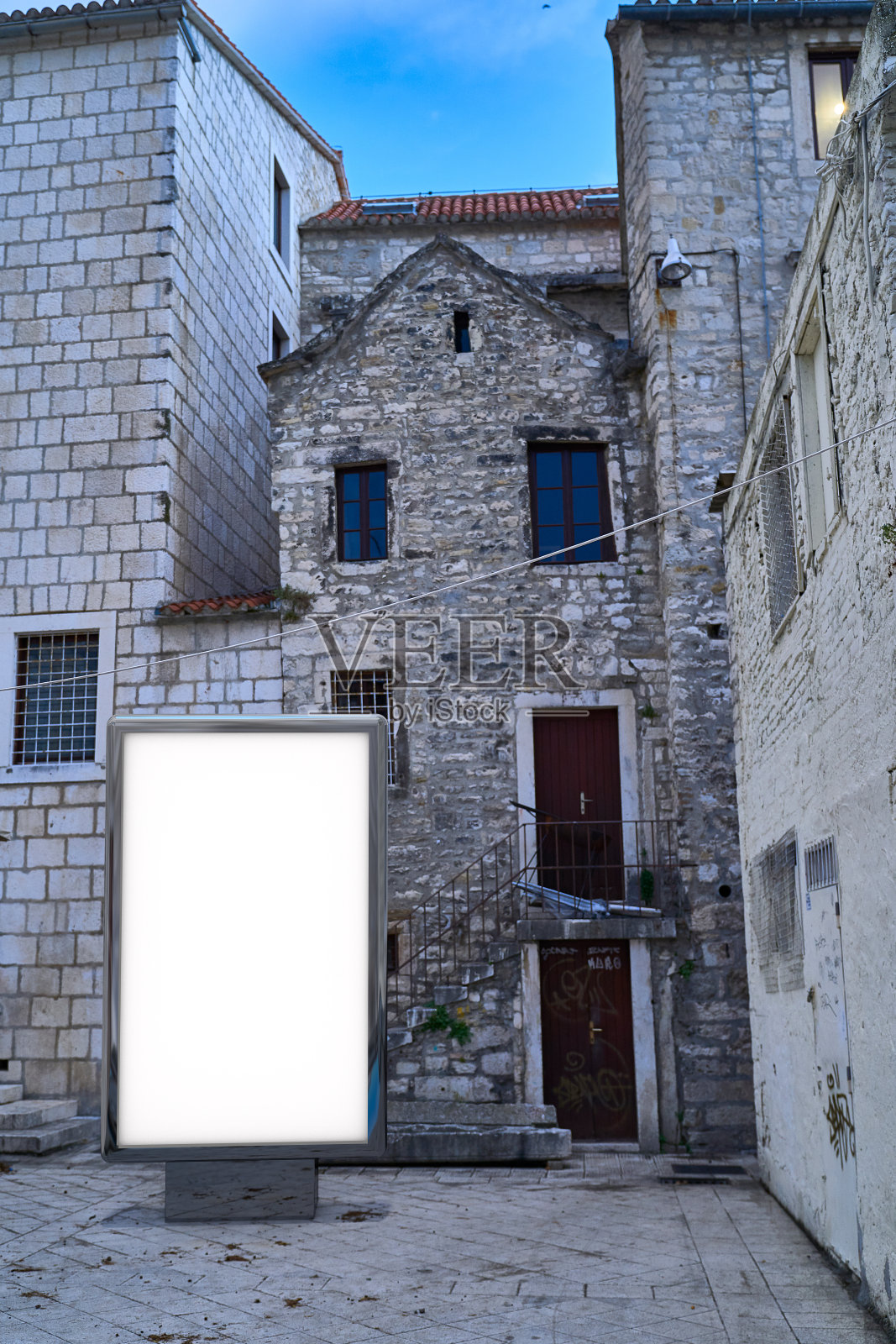 以旧城为背景的广告牌。街道上空白的广告牌模型照片摄影图片