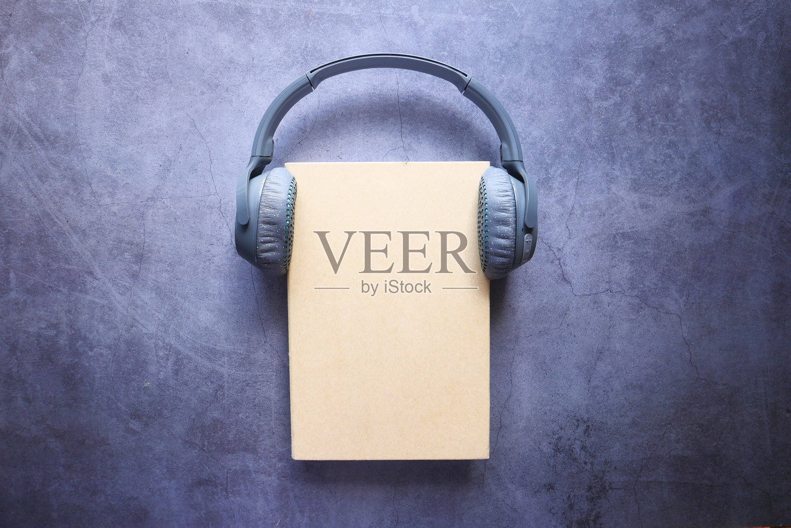 有声书的概念。耳机和书放在木桌上照片摄影图片